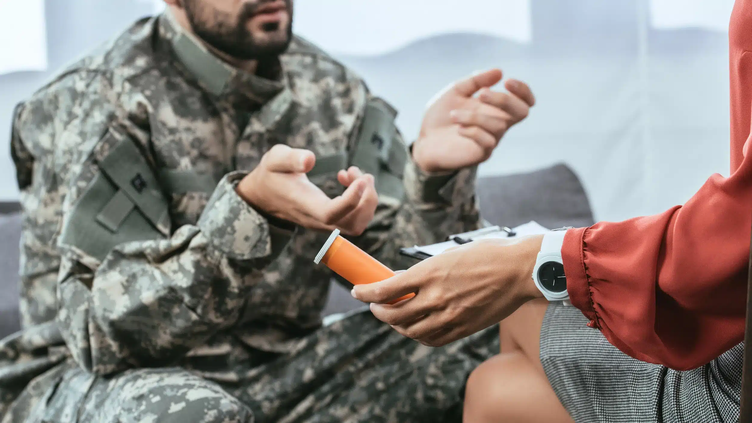 Man in army fatigues speaking to a psychiatrist. Text explains the relationship between PTSD and drug addiction.