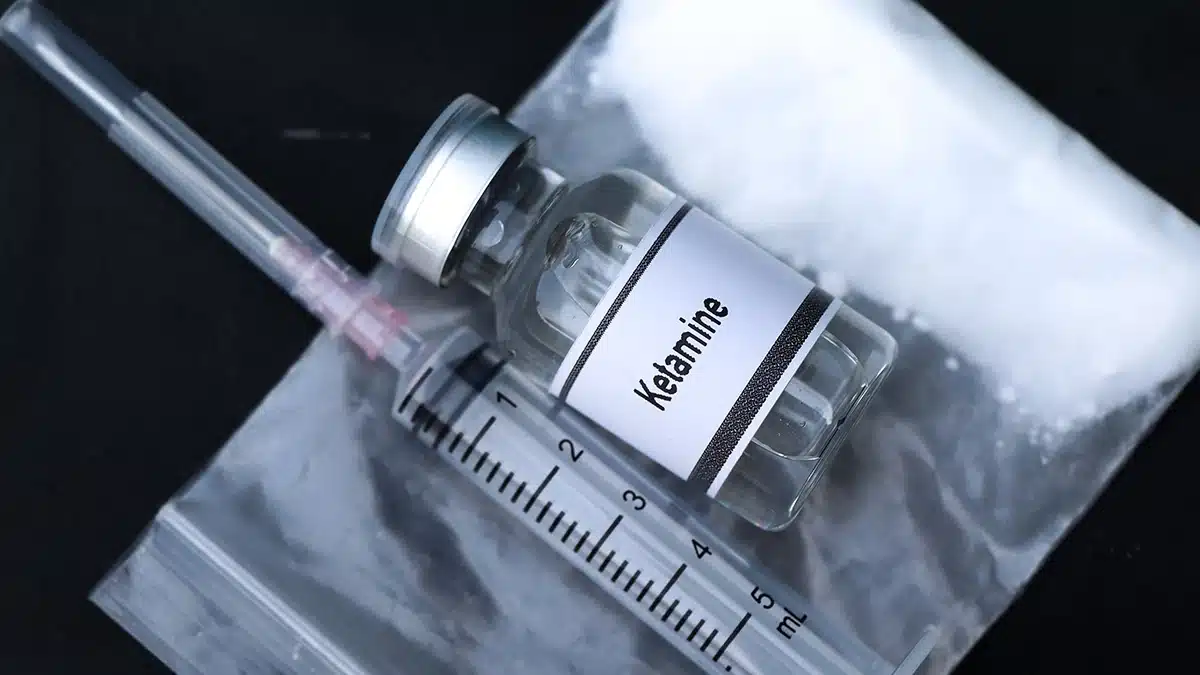 Clear medical vial and white powder.