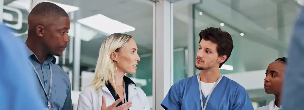 Nurses attentively listening to a doctor explain addiction risks.